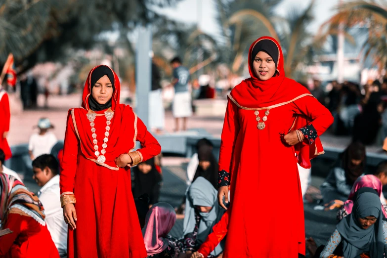 two women wearing red are standing side by side