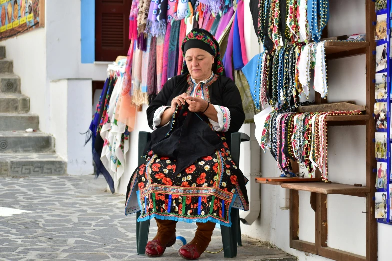 an older woman sits on a chair while she looks at her phone