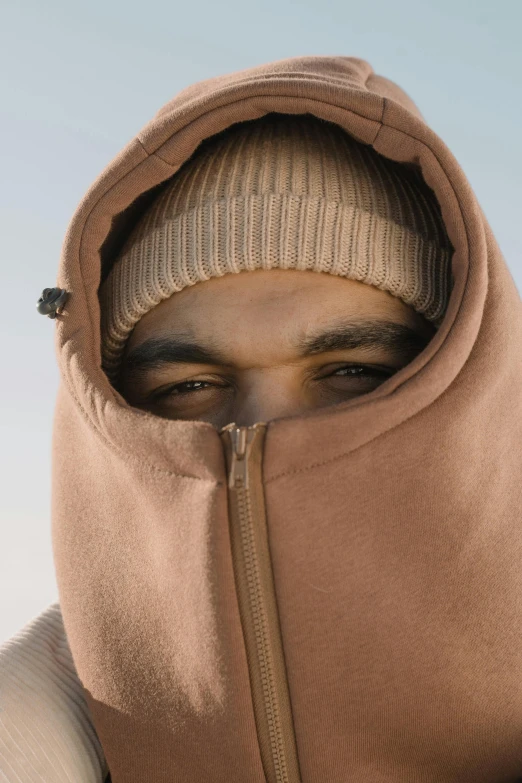 a hooded male is looking into the camera