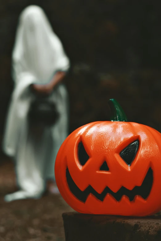 a creepy jack - o'- lanterns pumpkin sitting on a rock near a figure