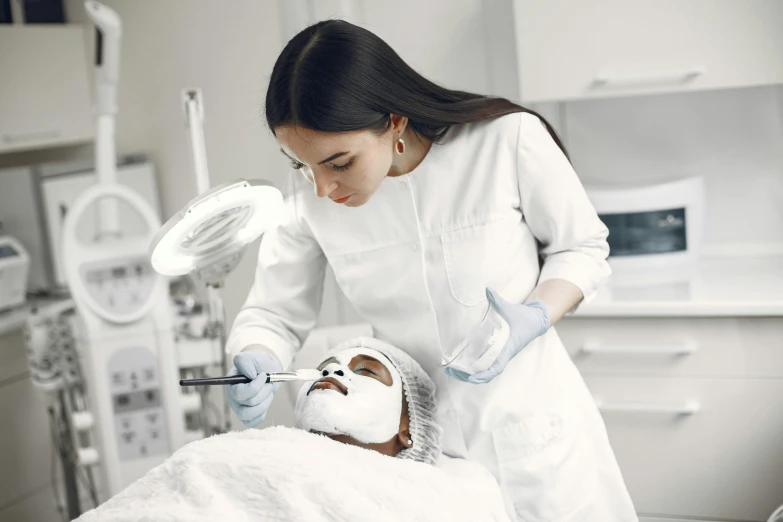 a woman looking at another person's eye with a medical device