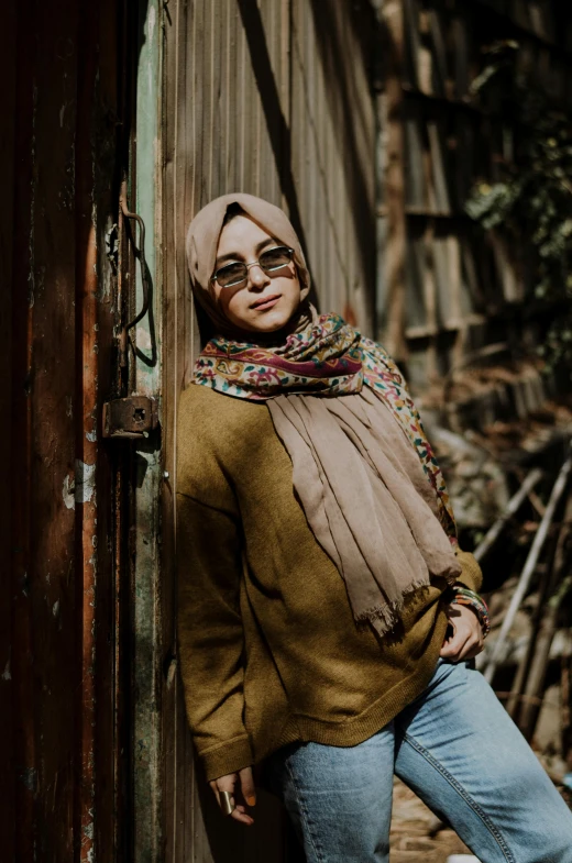 a woman standing outside wearing a scarna