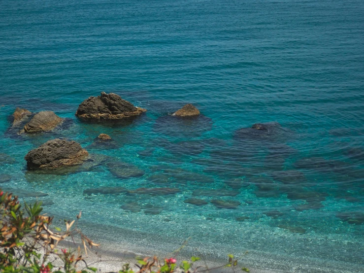 the clear water and rocks of the beach