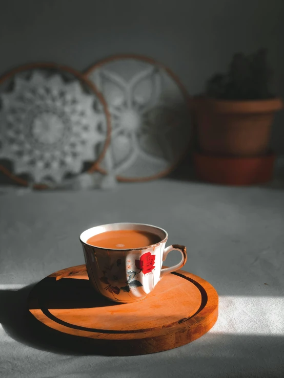 a cup of tea and saucer sitting on a place mat