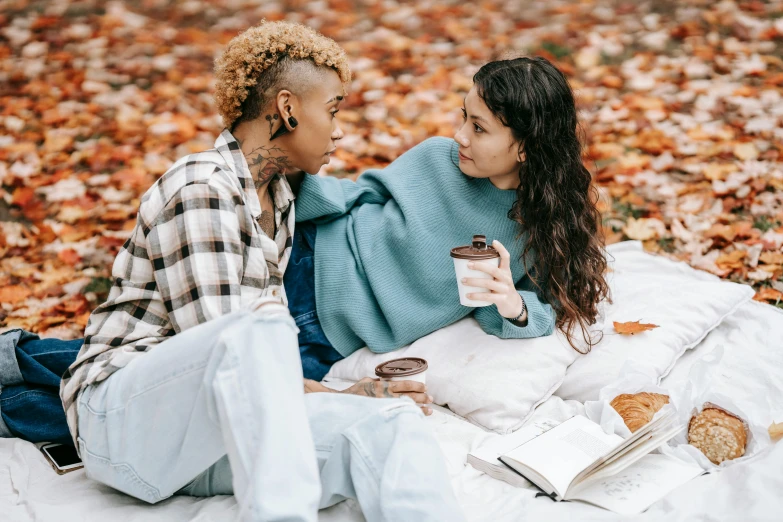 two woman eating and talking on the grass