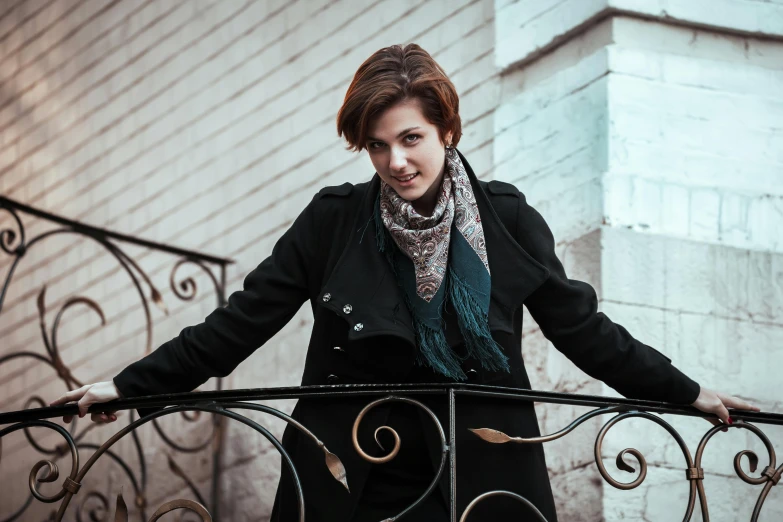 a woman in a black coat posing on the balcony