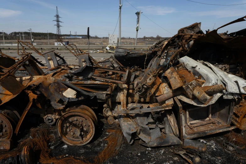 a pile of wrecked cars on the side of a road