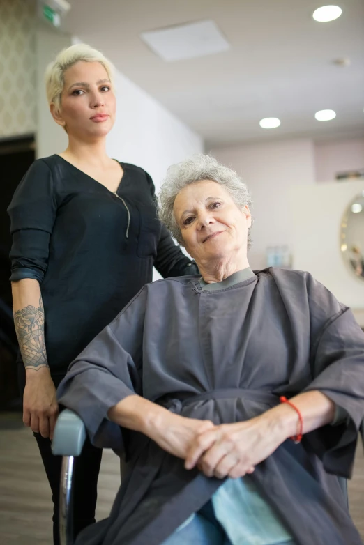 an older woman sitting in a chair next to another woman