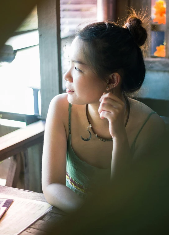 there is a woman sitting at a table with a book in hand