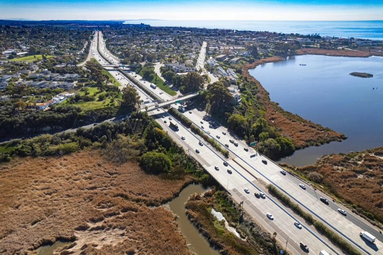 an aerial view of the road leading to a lake