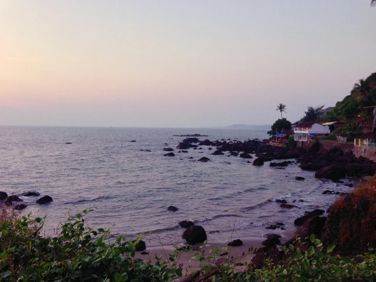 an ocean view at sunset with buildings on the shore