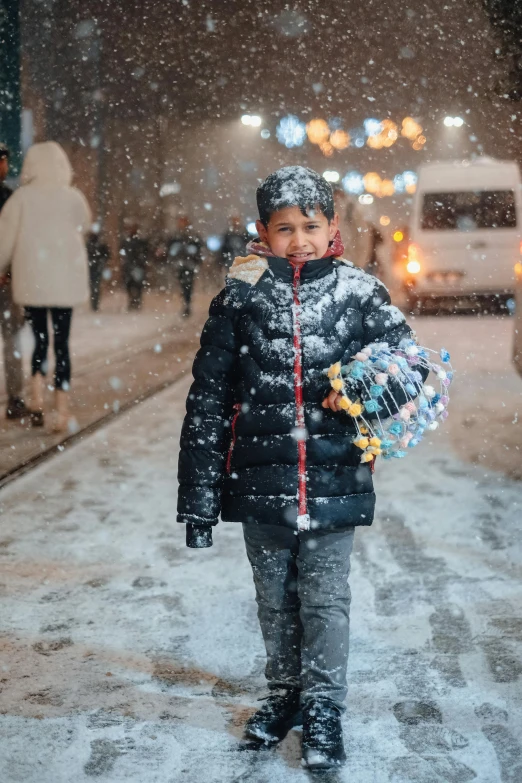 a little  in the snow walking down a street