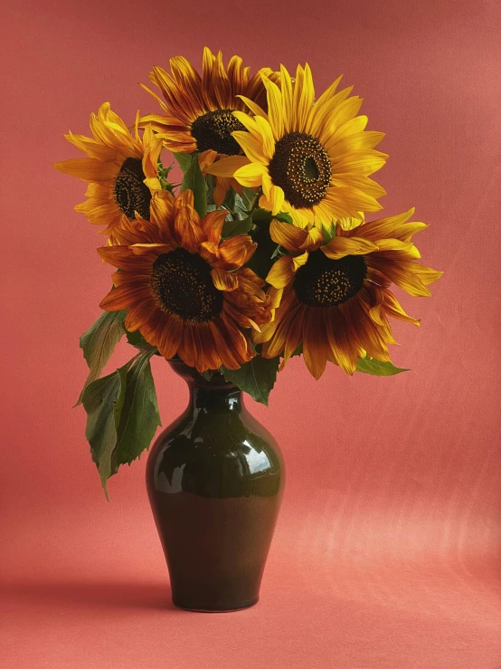 there is a vase full of flowers on the pink surface