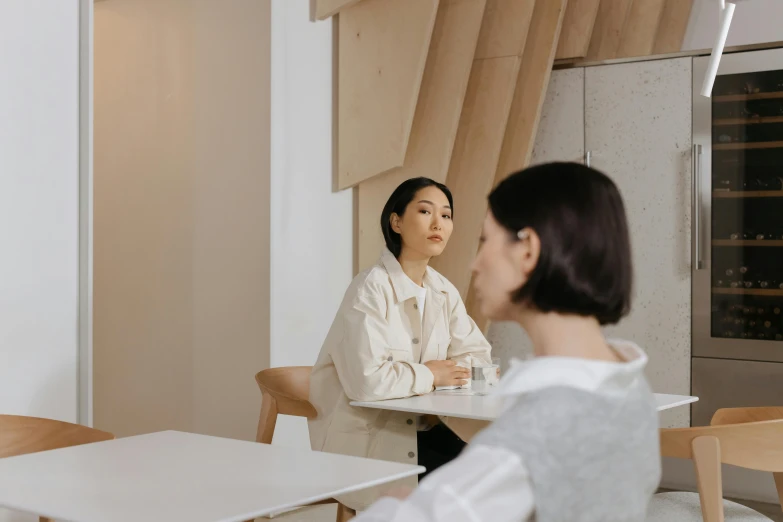 an asian woman talking to another young lady