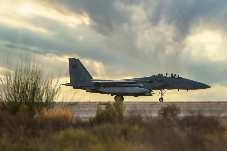 a jet fighter plane is taking off on an airport runway