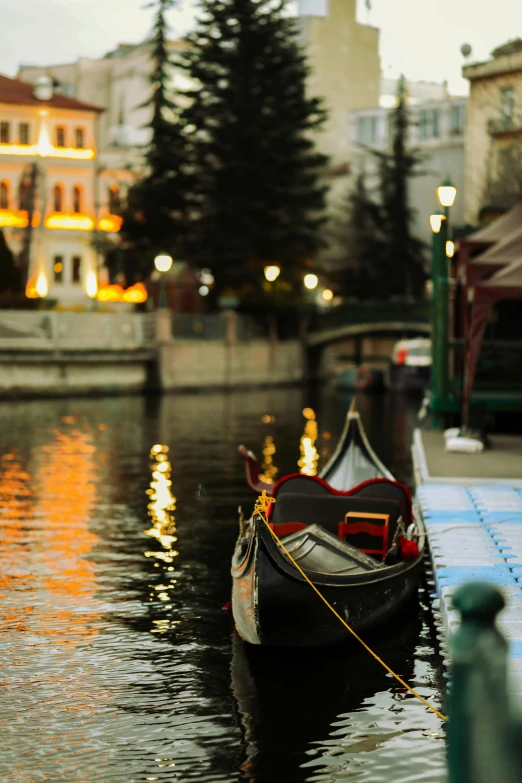 two small gondolas sitting next to the water in front of buildings