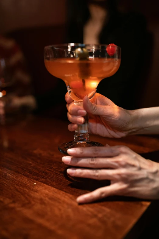 someone holds their hand near an empty wine glass