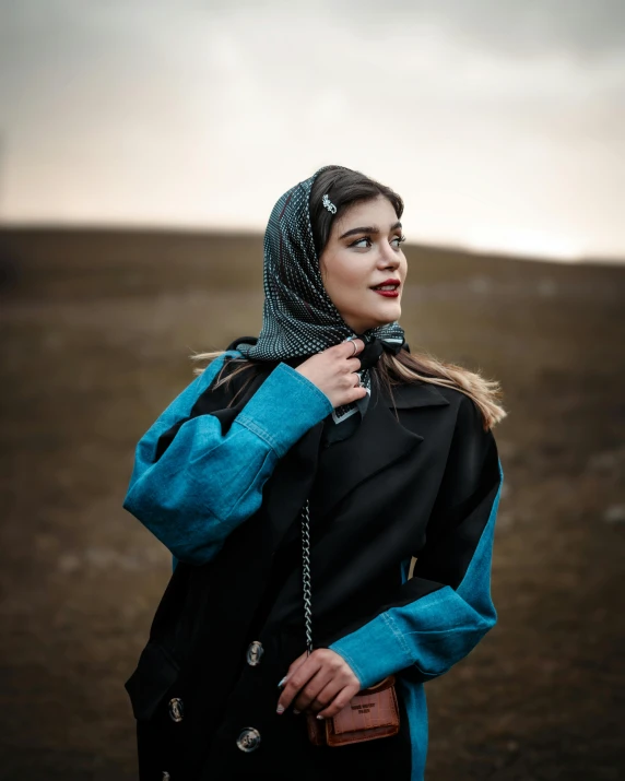 a woman standing in a large field with her head in her hand