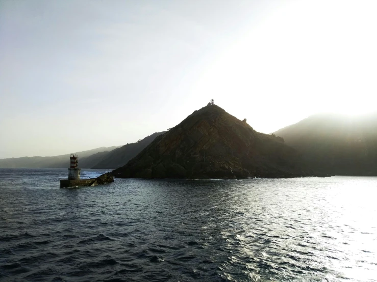 an island with a few mountains on the horizon