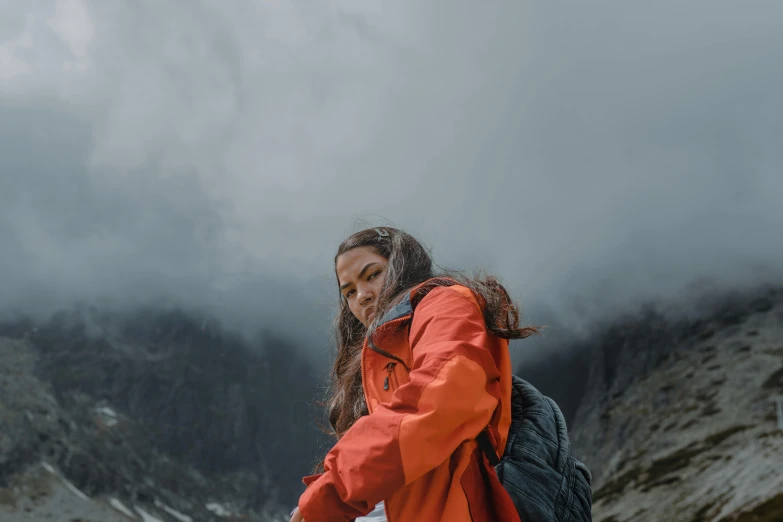 a woman is standing by the water holding a bag