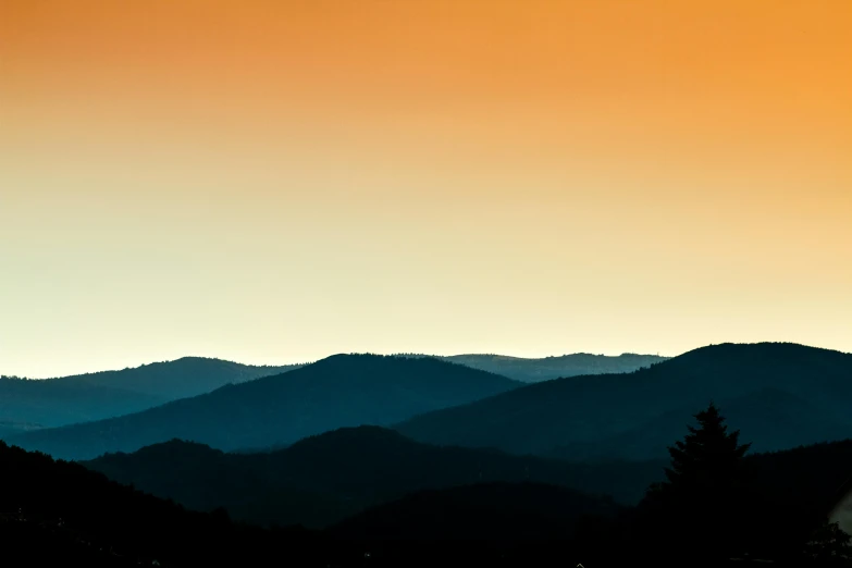 a group of mountains with trees in front