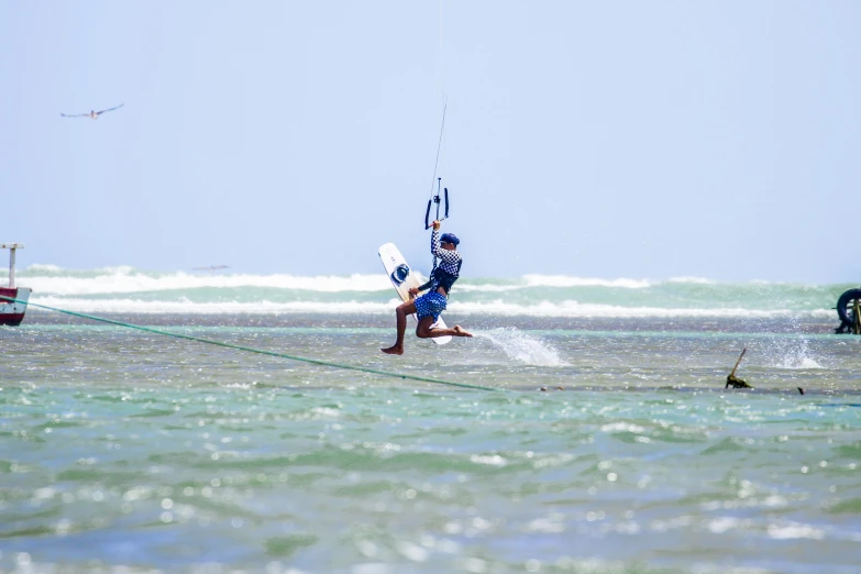 a man is holding onto a long string that is connected to a boat