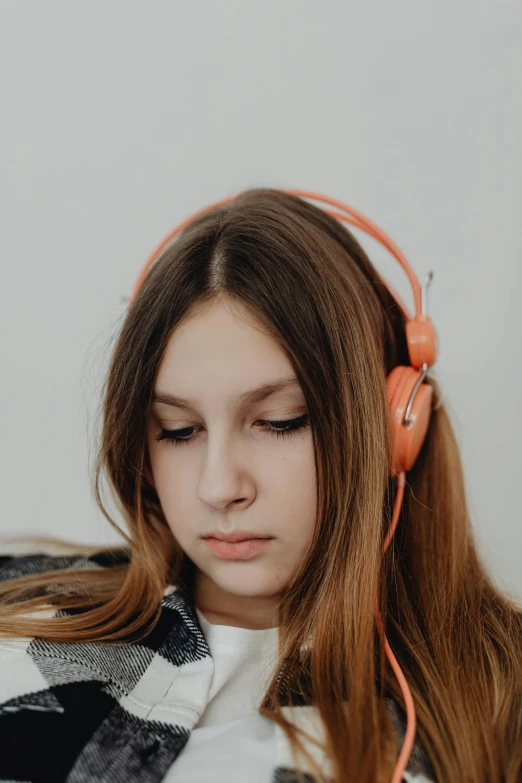 a girl is listening to music with headphones