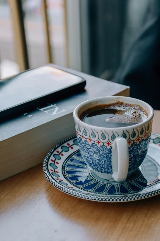 the coffee cup on the table is ready to be consumed