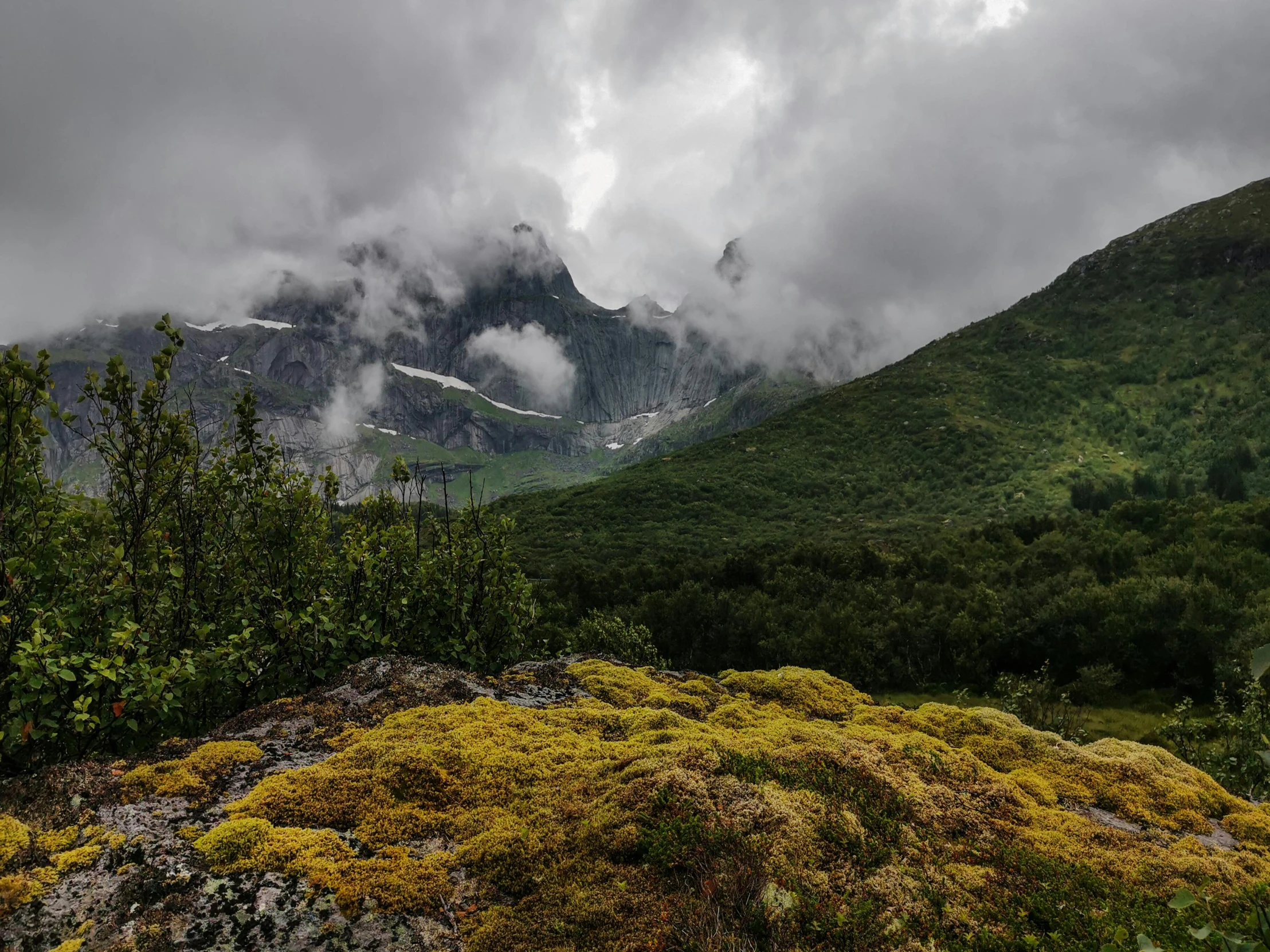 mountain landscape with clouds in the background and small patches of green on ground