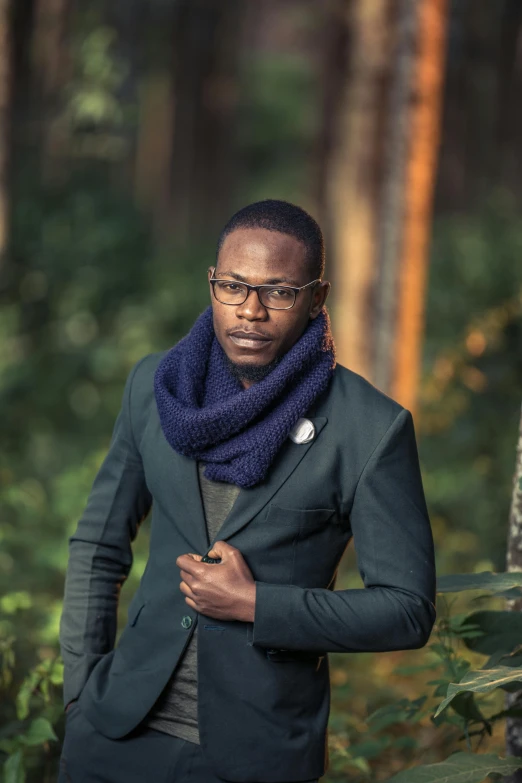 a man standing in front of a wooded area