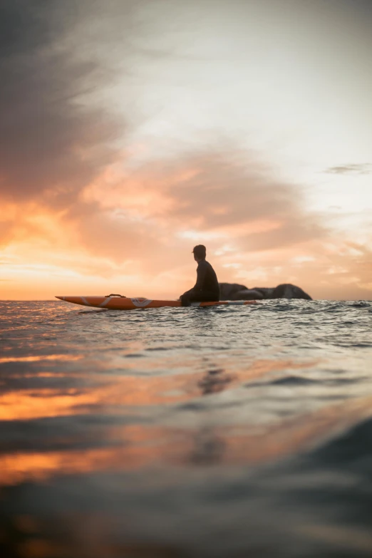 a person sitting on a surfboard in the water