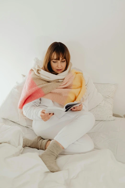 a person sitting on a bed and reading