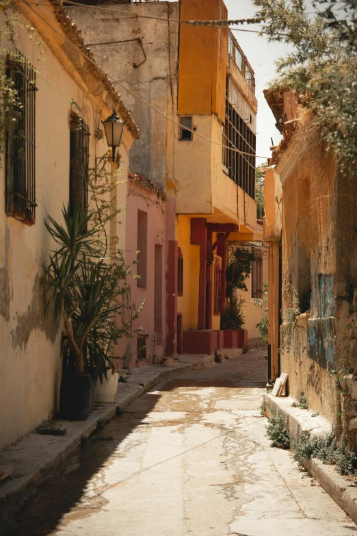 a view down a narrow alley way towards an adobe style building