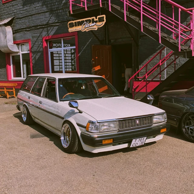 two older style cars in front of a building