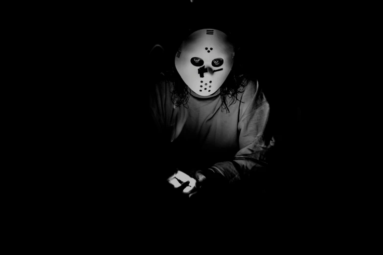 a man with an mask standing in the dark
