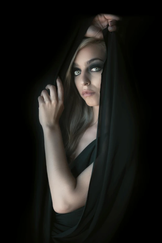 a woman with grey eyes and dark fabric dd around her head