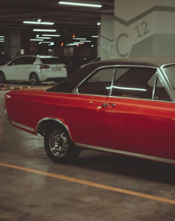 an old car sits parked in a parking garage