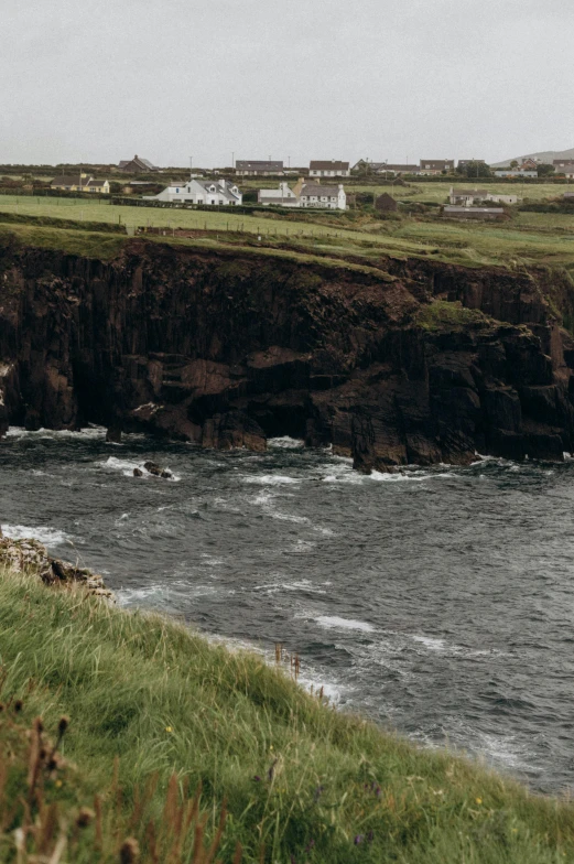 a body of water next to the shore near a hill