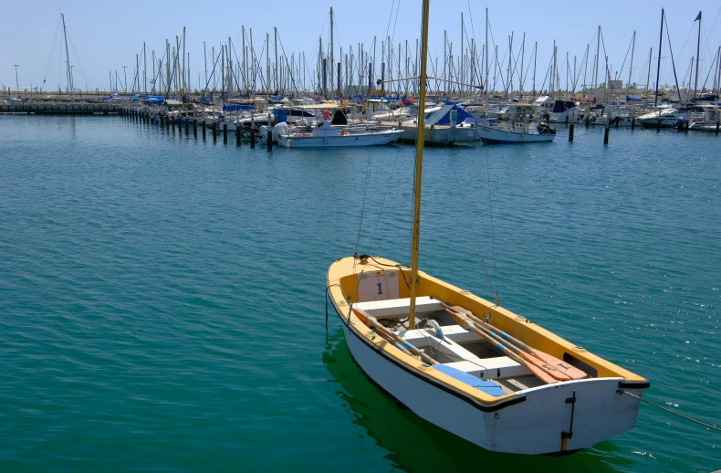 a small yellow and white boat floating in a large body of water