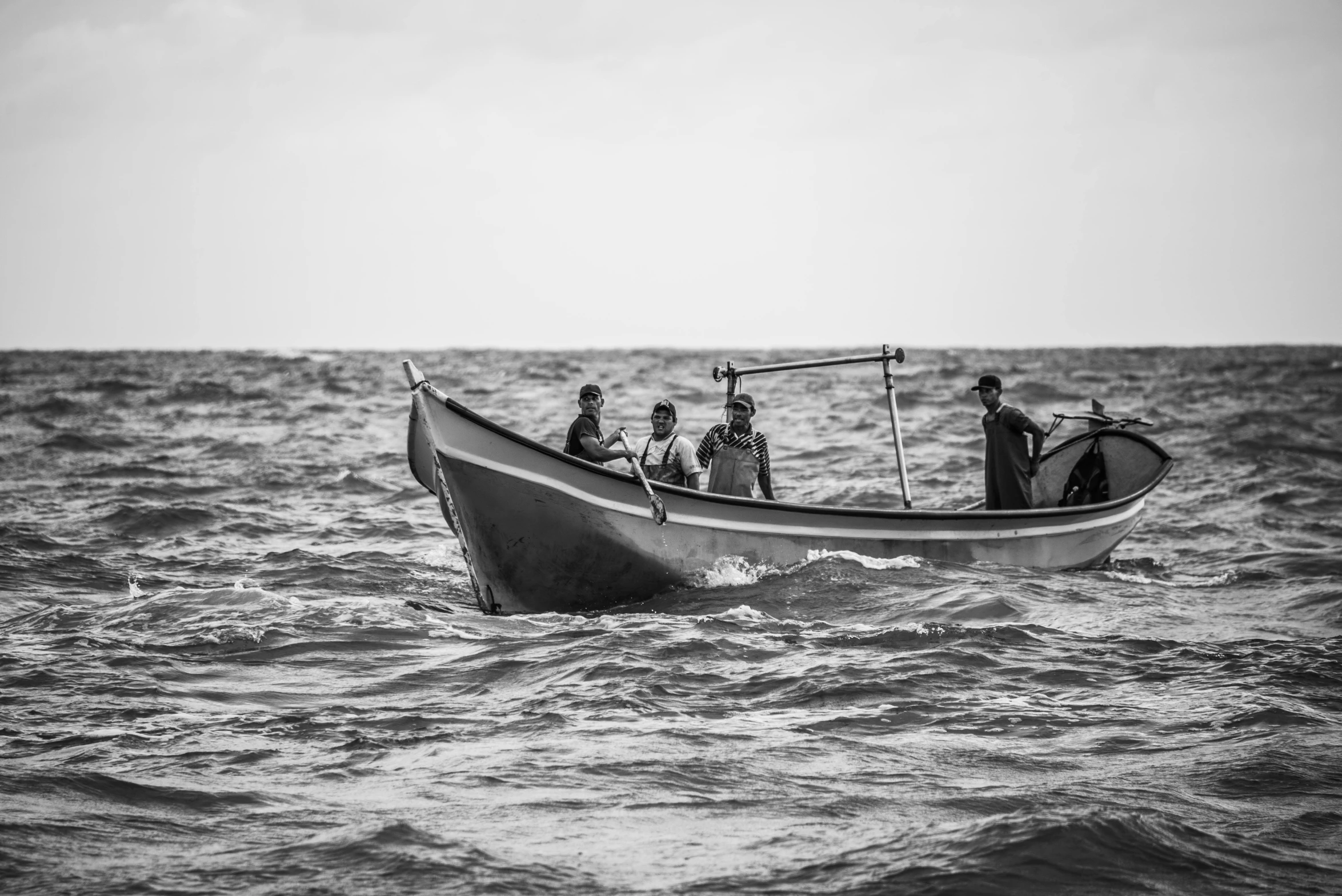 several men stand on a boat with ropes over it