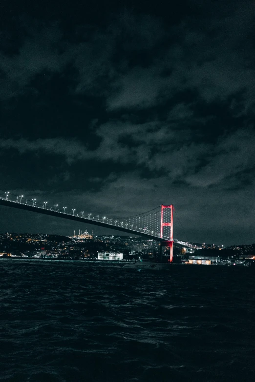 the bay bridge at night is lit up in red