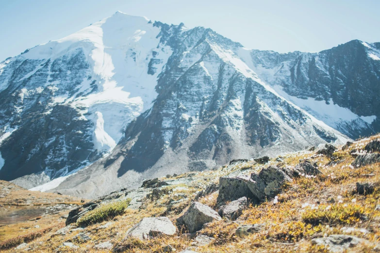 a woman is hiking along a grassy hillside