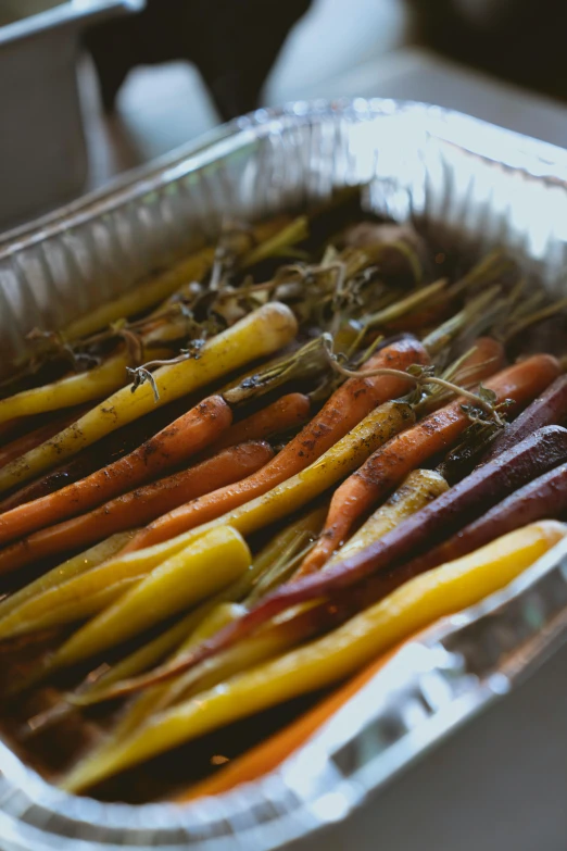 several colorful carrots in a tin pan ready to be cooked