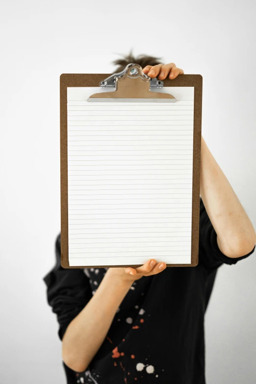 a woman holding up a blank note paper with clipping