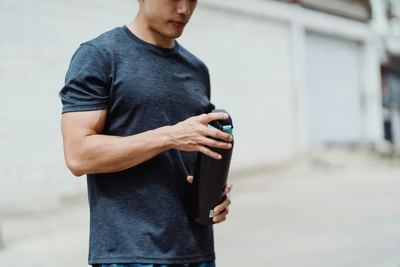 a man holds a case and looks down at his phone