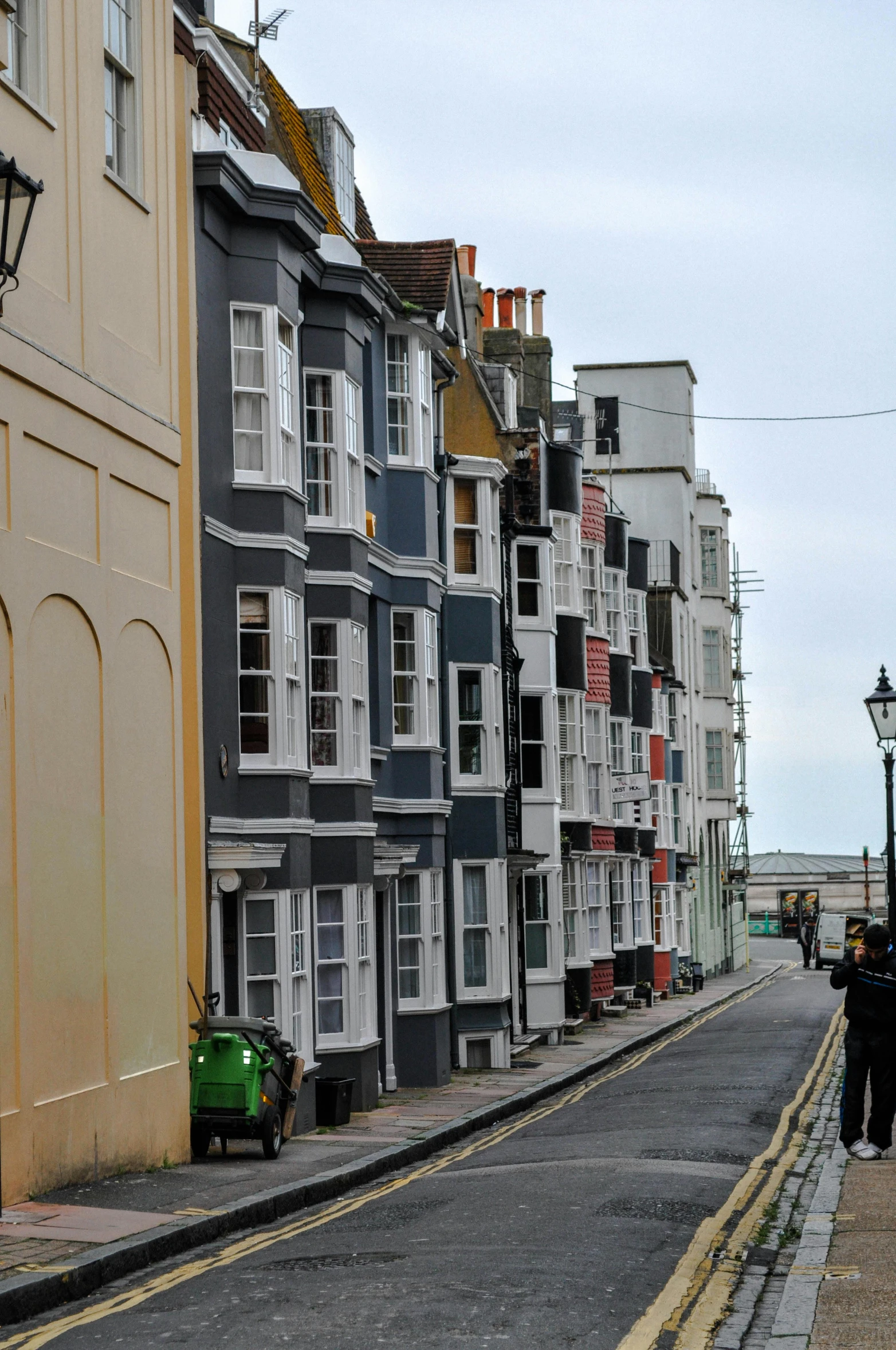 an old car is parked by a row of colorful houses