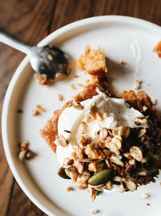 a plate of food has nuts, marshmallows and a spoon on it