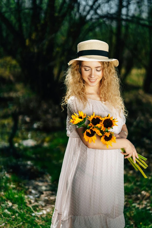 a pretty young blonde girl holding onto some sunflowers