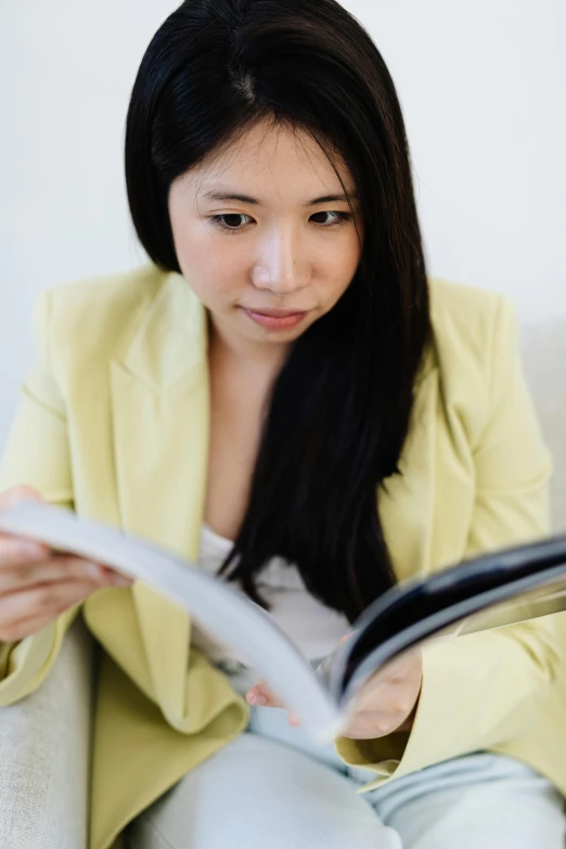 a woman is sitting on a couch reading a book