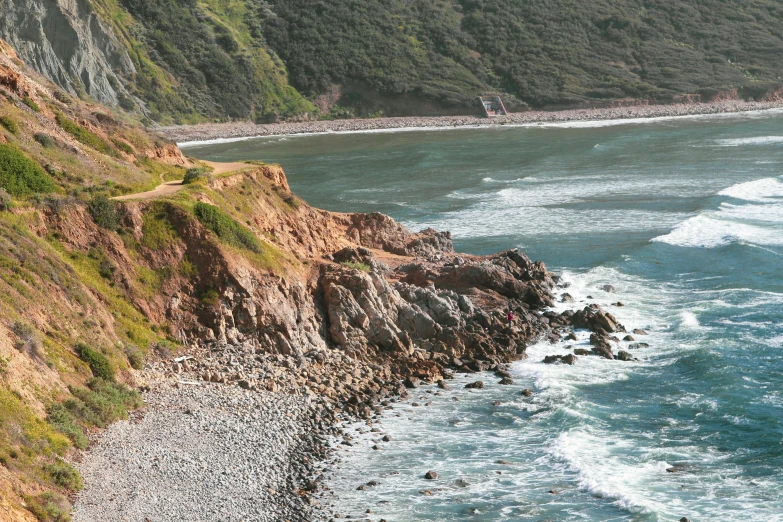 a picture of the coast with waves and people on it